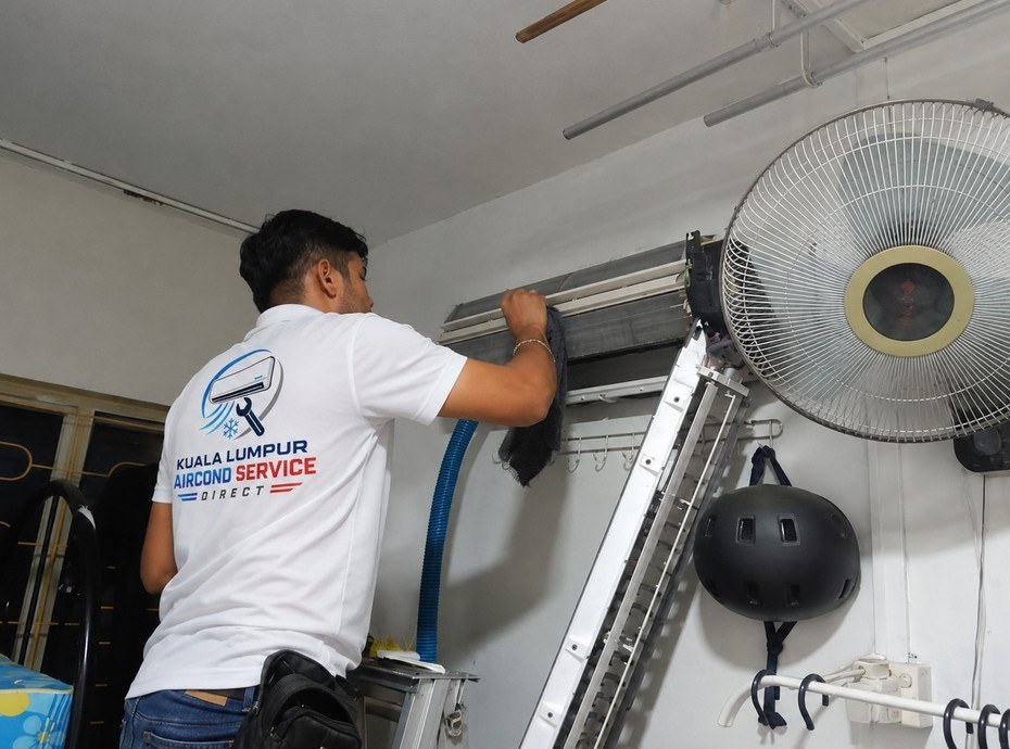 Kuala Lumpur Aircond Service Direct technician servicing a wall-mounted split unit in a KL apartment